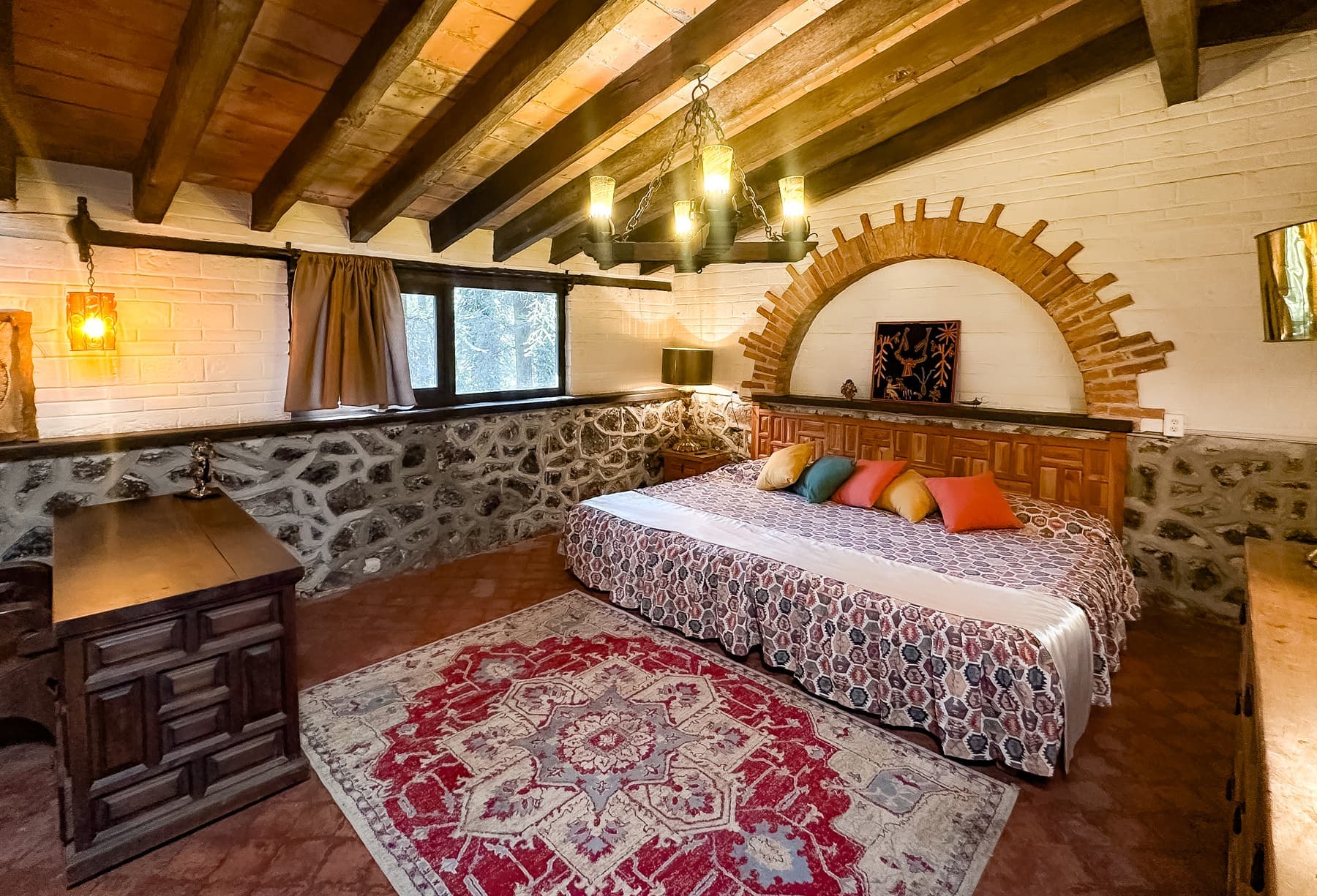 Recámara principal: cama king bajo el arco de ladrillo